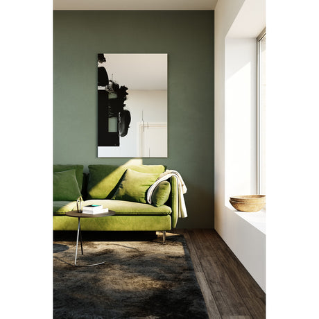 Connect II Brushstroke Printed Glass Wall Mirror 150cm, a frameless rectangular mirror with black brushstroke print, mounted above a green sofa in a living room setting.