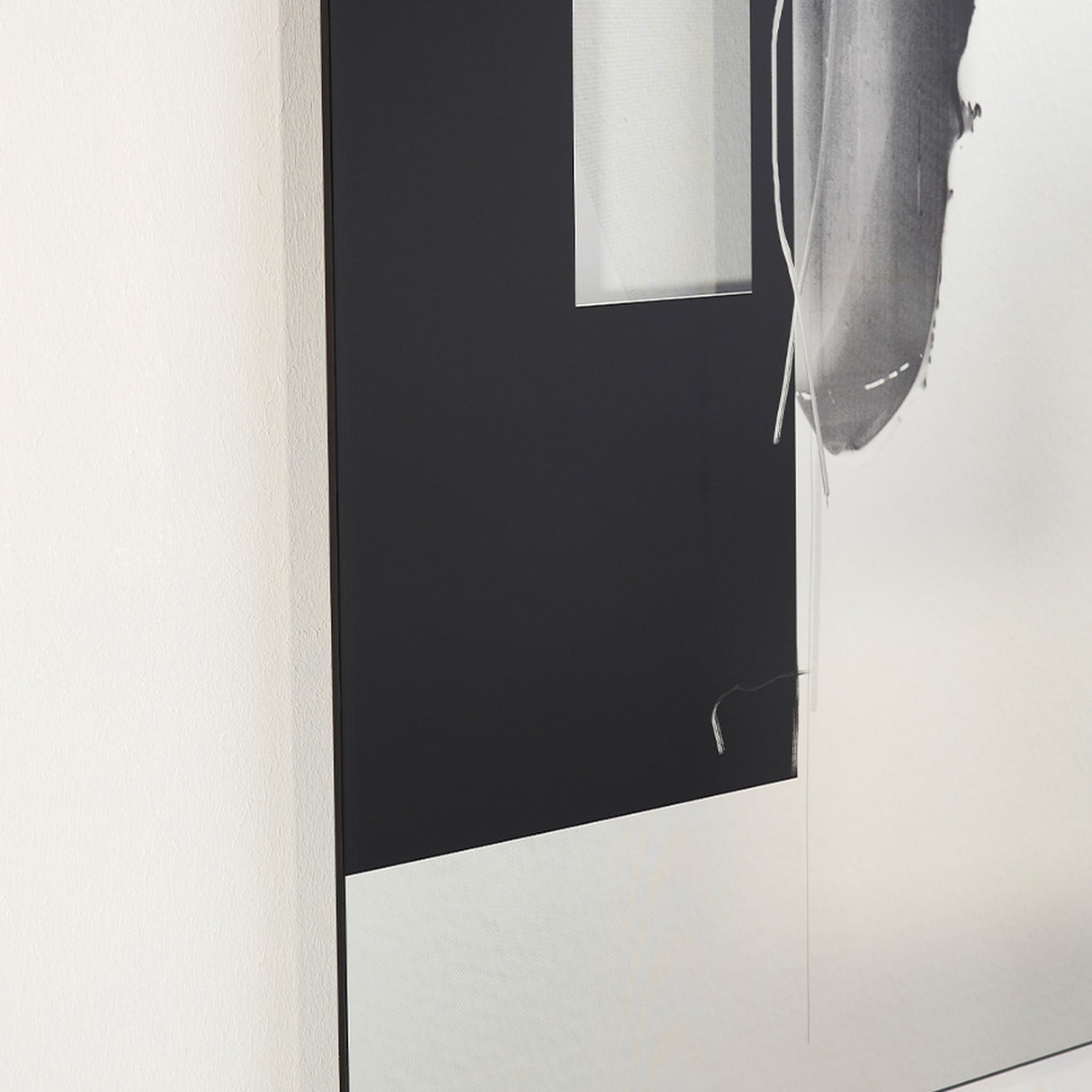 Angled close-up of the Connect II Brushstroke Printed Glass Wall Mirror 150cm, a frameless rectangular panel with a black block, grey brushstroke print and mirrored sections on a white wall.
