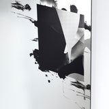Angled close-up of the Connect III frameless glass wall mirror, 105cm, with a torn black printed form revealing a greyscale photographic image beneath, mounted against a white wall.