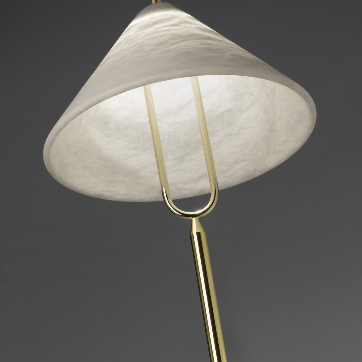 Close-up of the Fuji LED floor lamp's conical alabaster shade with cloudy veining, held by a U-shaped polished brass yoke on a slender brass stem.