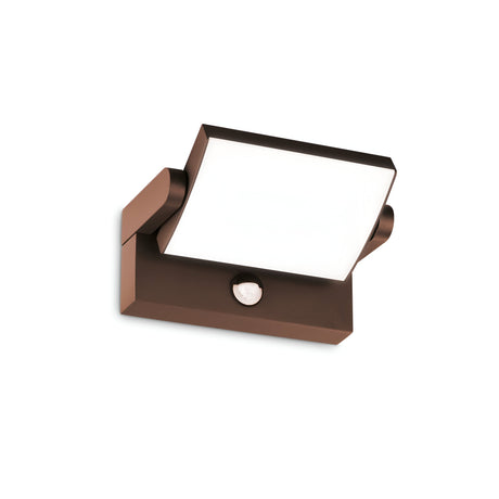 Introducing the Solstice LED Outdoor Motion Sensor Wall Light 21W 3000K - Brown, a contemporary outdoor fixture boasting a sleek, square, white panel. This stylish and minimalistic design is supported by a rustic brown finish base with an unobtrusive circular sensor beneath. Crafted from powder-coated aluminum, it seamlessly combines form and function.