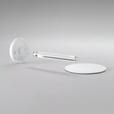 Minimalist photo featuring the contemporary design of the Solixis LED Table Lamp 3.6W 3000K - White: it includes three geometric elements—a circular white base, a clear cylindrical rod at its core, and a round white disc in the background—all arranged on a light gray surface. Ideal for battery-operated elegance.