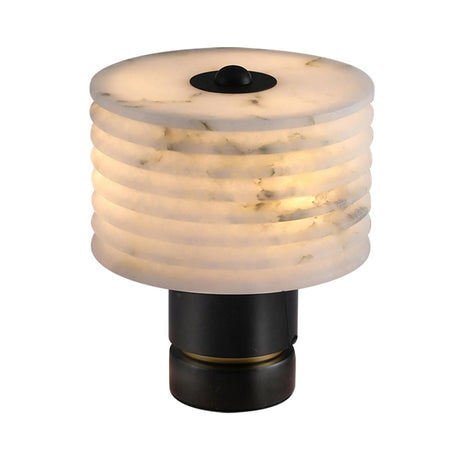 The Stravion 1 Light Large Ribbed Marble & Alabaster Table Lamp in Soft White & Black features a cylindrical, subtly marbled white shade on a black base, casting a warm and inviting glow when turned on.