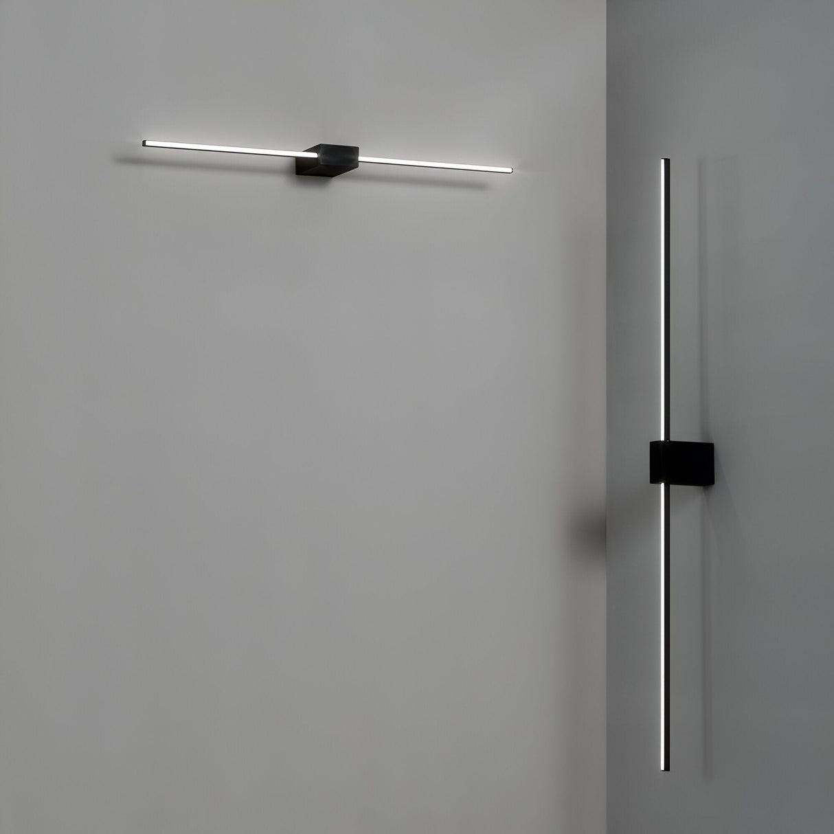 The minimalist wall lights from the Helion LED Picture Light collection adorn a grey surface, elevating contemporary interiors. A horizontal Helion LED Picture Light 13.5W 3000K - Black, 75cm is installed on the left wall, while a vertical one enhances the right. Each light showcases an elegant design with slender illuminated lines and a matte black finish for a modern touch.