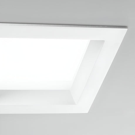 A Radiara-2 Square LED Recessed Downlight 215mm - 25W, with a modern design, emits a bright glow against a smooth, white ceiling. Its LED bulb produces a minimalist and clean appearance with its 3000K warm illumination.