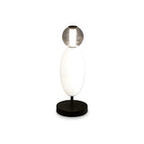 Introducing the Gleara Table Lamp - White, featuring a sleek and contemporary design with a circular base, an elongated oval body, and a round clear lampshade at the top that houses an LED light. Its minimalist black and white color scheme enhances any modern decor.