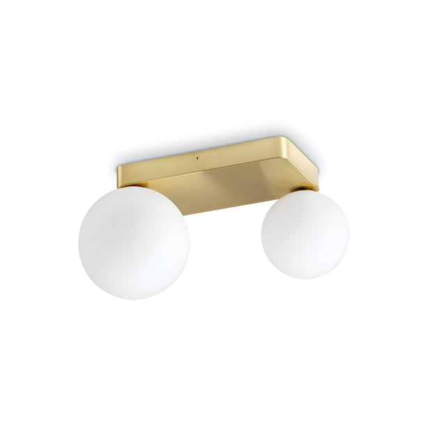 The Luxis 2 Light Wall Light - Gold features a modern design with two round, white blown glass diffusers attached to a rectangular, gold-colored base.