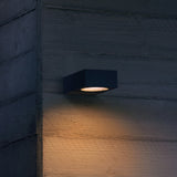Sirio coffee outdoor wall light on an exterior wall at dusk