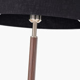 Close-up of the Gianni floor lamp's brushed silver neck joint linking a black linen shade to a wood-effect stem.