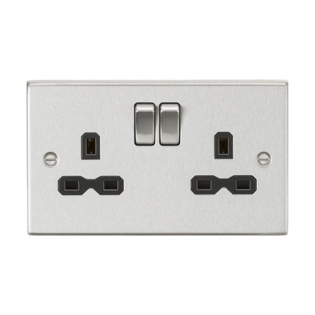 The 13A 2 Gang DP Switched Socket with Twin Earths in brushed chrome (featuring a black insert and square edge) elegantly showcases two three-prong outlets and two switches, adding a decorative touch to any room.