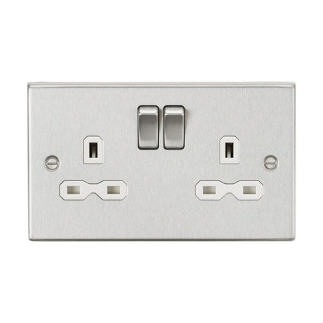 The 13A 2 Gang DP Switched Socket with Twin Earths in brushed chrome boasts a sleek rectangular plate with a square edge design. This socket features two switches positioned above the outlets, each having three holes arranged in the standard UK pattern, and incorporates a stylish white insert to enhance modern elegance and functionality.