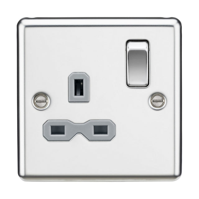 A close-up of the 13A 1 Gang DP Switched Socket reveals its three rectangular pin holes, off switch, and polished chrome accents. The modern design is completed with a grey insert and rounded edges, featuring two screws on either side that both secure it to the wall and enhance its decorative appeal.