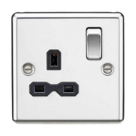 A detailed view of the 13A 1 Gang DP Switched Socket in polished chrome reveals a switch and two black plug sockets. The design, with rounded edges, features two screws on either side, highlighting its sleek, modern style enhanced by a decorative touch.