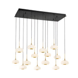 The Aurevia 14 Light LED Dome Alabaster Bar Pendant Light features fourteen alabaster dome shades with gold accents, suspended at varying heights from matte black cables for a modern linear chandelier look.