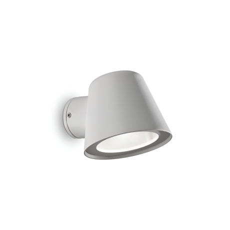The Quasar Outdoor Wall Light in grey features a sleek, minimalist design with a white conical shade and circular base that casts soft illumination. This weather-resistant fixture elegantly enhances your exterior spaces when set against a plain white background.