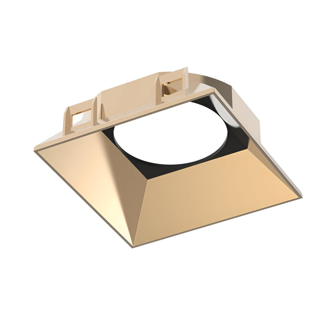 The Glistenis Reflector Square Frame 89mm in gold features an angled, reflective interior and a circular opening at its center. Its modern, geometric design makes it ideal for contemporary lighting installations.