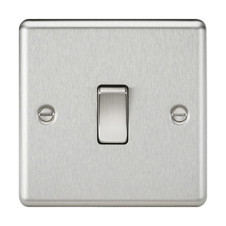 A 10AX 1 Gang 2-Way Switch - Brushed Chrome (Rounded Edge) is mounted on the wall, showcasing a polished metal finish with two visible screws on either side. Its sleek design and modern aesthetics add both functionality and elegance to any room.