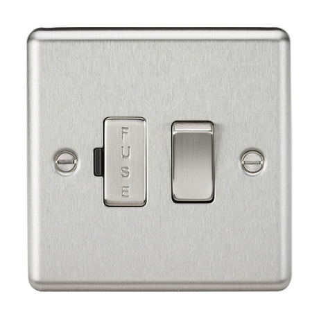 The 13A Switched Fused Spur Unit - Brushed Chrome features a metallic light switch plate with a brushed chrome finish. It includes a switched fused spur on the left labeled "FUSE" and a standard toggle switch on the right. The rounded edge metal design is secured with two visible screws.