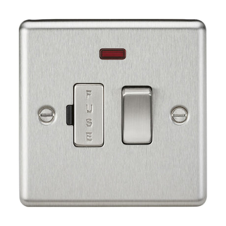 The 13A Switched Fused Spur Unit Neon in brushed chrome boasts a sleek design with a red indicator positioned above it, along with two screws on either side. This vertically oriented switch features rounded edge metal and includes a white section labeled "FUSE" on the left.