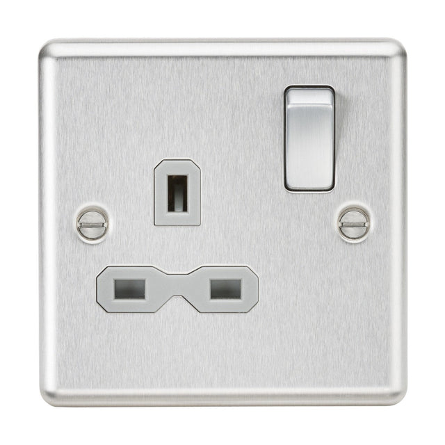 The 13A 1 Gang DP Switched Socket in brushed chrome comes with a grey insert and rounded edge design. It features a single switch on the right and a UK-style three-pin plug socket on the left, adding a decorative touch. Two screws are visibly placed on each side of the socket.