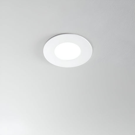 A circular Solix LED Recessed Downlight - 7W, 4000K in white emits a soft glow from the ceiling, contrasting beautifully with the smooth light gray background and highlighting its energy-efficient brilliance.
