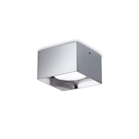 The Orbis Square Downlight - Chrome is a minimalist ceiling light fixture with a sleek, metallic chrome finish and a frosted glass bottom. It is equipped with an LED light source to evenly distribute soft, ambient lighting in modern interiors.