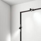 The modern minimalist decor in this space is exemplified by a white corner wall that features sleek, linear black light fixtures. Mounted on the frame are two Viora Magnetic Dimmable LED Track Spotlights, each offering a subtle and energy-efficient 3W 3000K illumination across the surfaces.