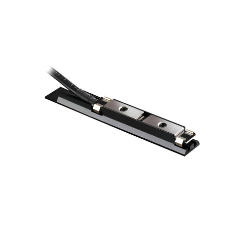 Close-up of the Viora Magnetic Track Lighting Power Input Connector in black, showcasing its sleek, rectangular design with a cable attached, highlighting the metal components on a flat base. The cable emerges from one end, indicating electronic connectivity and customizable cable length for precise installations.