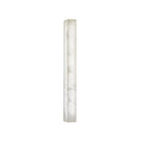 The Valmera LED Small Slim Vertical Alabaster Wall Light features a tall, slender rectangular design with a frosted white marbled look, emitting a soft, diffused glow.