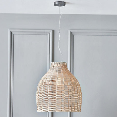 Caswell Rattan Cloche pendant light with natural woven bell-shaped shade on chrome fitting, hanging from a ceiling rose against a grey panelled wall.
