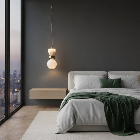 Modern bedroom with a large window, neatly made bed with white linens and green accents, floating nightstand, and the Elarin LED Stacked Alabaster Single Pendant Light in Soft White & Brushed Brass for contemporary elegance.