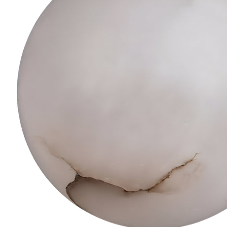 A close-up of the Lyvane 3 Light Globe Alabaster Cluster Pendant Light in soft white and matte black, featuring smooth natural Spanish alabaster with a visible crack and chip near the bottom edge, set against a white background.
