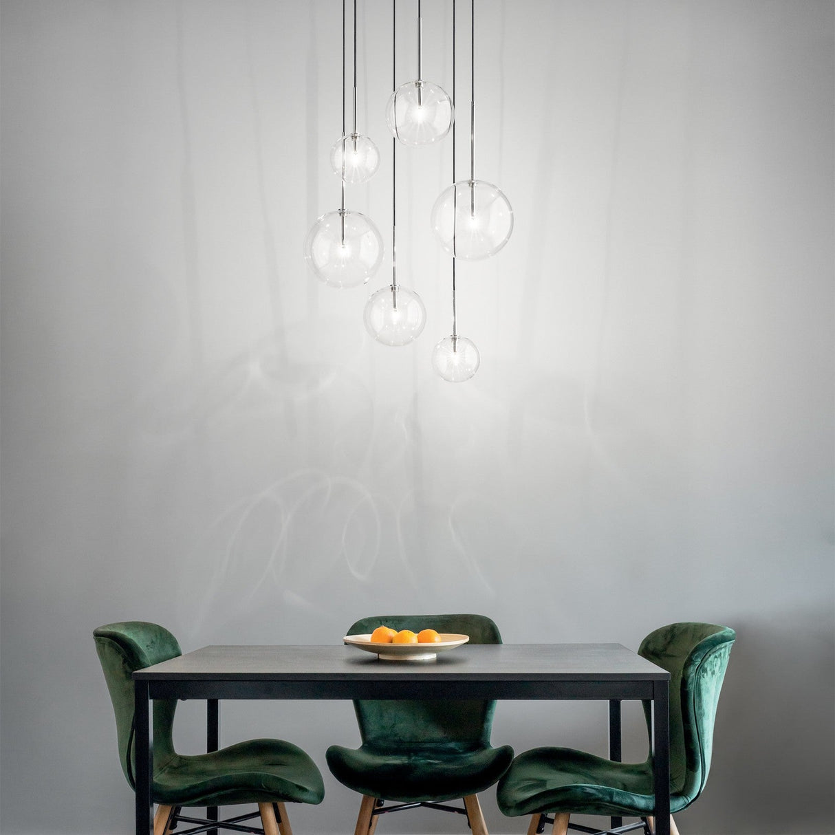 Equinoxe amber glass globe chandelier over a dining table