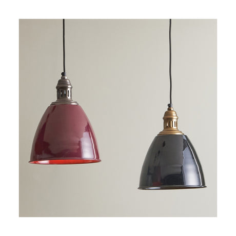 Piccolo dome pendant shades in glossy black and dark red metal with dark metal fittings, hung side by side against a plain light grey background.