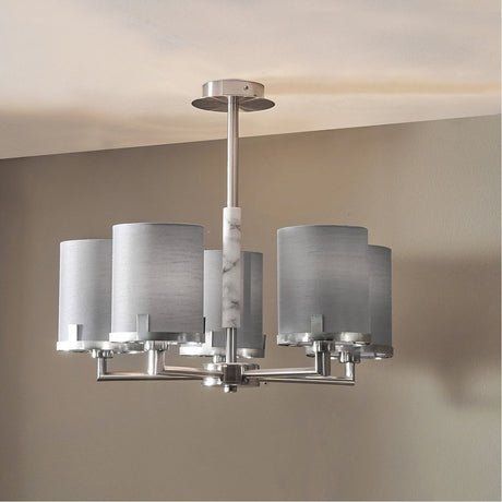 Midland 5-arm pendant light in brushed nickel with grey fabric cylinder shades and a marble-effect centre column, shown hanging from a ceiling in a room setting.