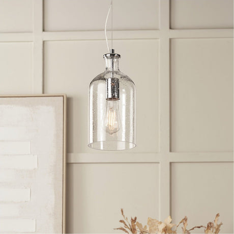 Bellamy Clear Glass Bubble Pendant Light, 15cm, with seeded glass shade and chrome fitting, shown lit with exposed bulb against a panelled wall.