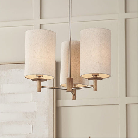 Bonham 3-light pendant with cylindrical linen shades, wood veneer holders and a silver metal frame, shown hanging in a neutral dining room setting.