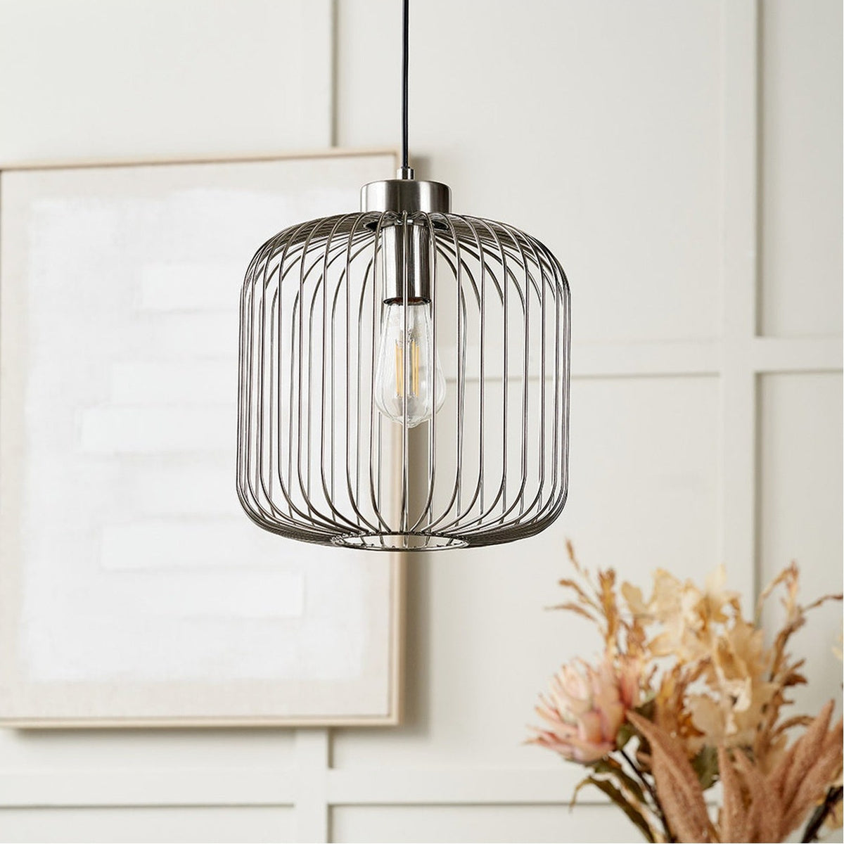 Dania Silver Metal Wire Pendant Light, 30cm, cylindrical steel cage shade with exposed bulb, shown hanging in a neutral living room setting.