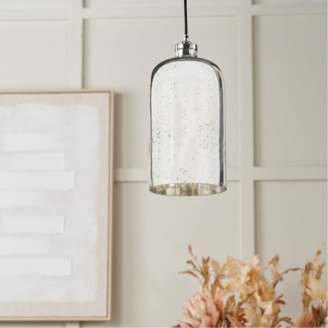 Ophelia Mercurial Glass Pendant Light - 18cm, a cylindrical speckled glass shade with chrome fitting, hanging in a room with panelled walls and framed art.