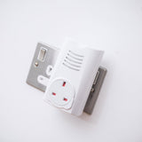 AVSL Mercury DB300 plug-through wireless door chime receiver in white, plugged into a chrome UK socket with vented speaker grille and 13A pass-through outlet.