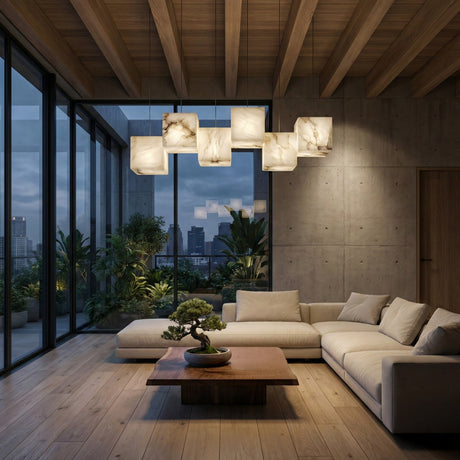 A modern living room with large windows, wooden floors and ceiling, a beige sectional sofa, a square wooden coffee table with a bonsai, lush green plants, and the Elmyra 6 Light Linear Alabaster Bar Pendant Light in soft white.