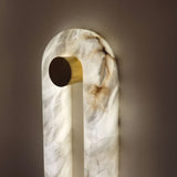 Serava LED Alabaster Wall Light Large in soft white, close-up of the arched stone body with brass cylindrical bracket, showing natural veining and warm integrated LED glow against a plain wall.