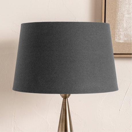 Winston Grey Handloom Tapered Lampshade, 45cm, fabric shade in grey shown fitted on a brass-toned table lamp base against a neutral wall.