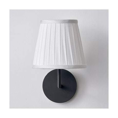 Lyndon Ivory Silk Mix Knife Pleated Tapered Lampshade, 18cm, shown on a black wall light fitting against a plain white background.