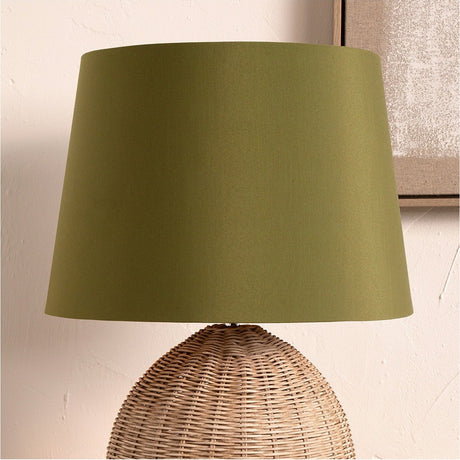 Adelaide Sage Tapered Cotton Mix Lampshade - 40cm, a tapered fabric shade in sage green, shown fitted on a woven rattan table lamp base against a neutral wall.