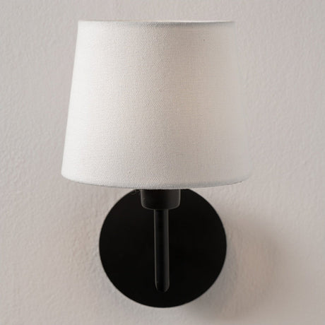 Pelham White Handloom Tapered Candle Clip Lampshade, 15cm, fabric shade on a black wall sconce fitting, shown against a plain light background.