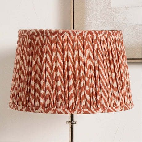 Vienna Red Chevron Pleated Lampshade, 50cm, drum-shaped fabric shade in red and cream zigzag pattern, shown fitted on a floor lamp with chrome base.