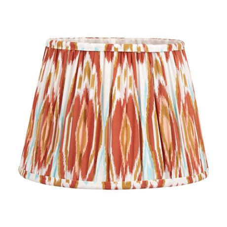 Izara Cinnamon Ikat Pleated Tapered Lampshade, 30cm, in fabric with a rust, gold, and cream ikat print and gathered pleats, shown on a plain white background.
