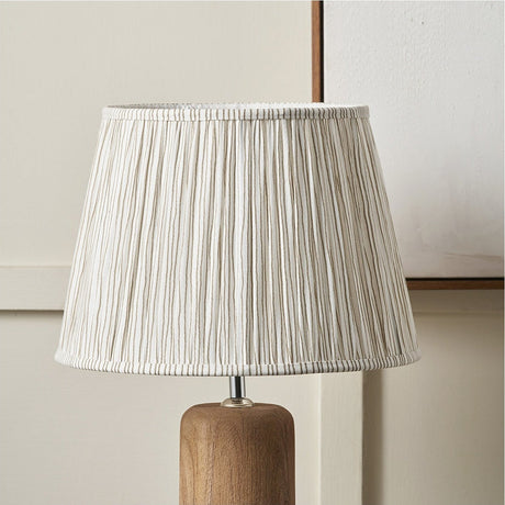 Thiago Natural Stripe Pleated Tapered Lampshade, 30cm, in pleated fabric with subtle vertical stripes, shown on a wooden lamp base against a light interior background.