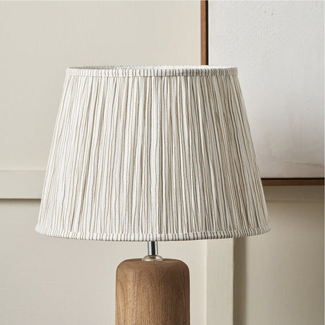 Thiago Natural Stripe Pleated Tapered Lampshade, 35cm, in gathered striped fabric with white lining, shown fitted on a wooden table lamp base.